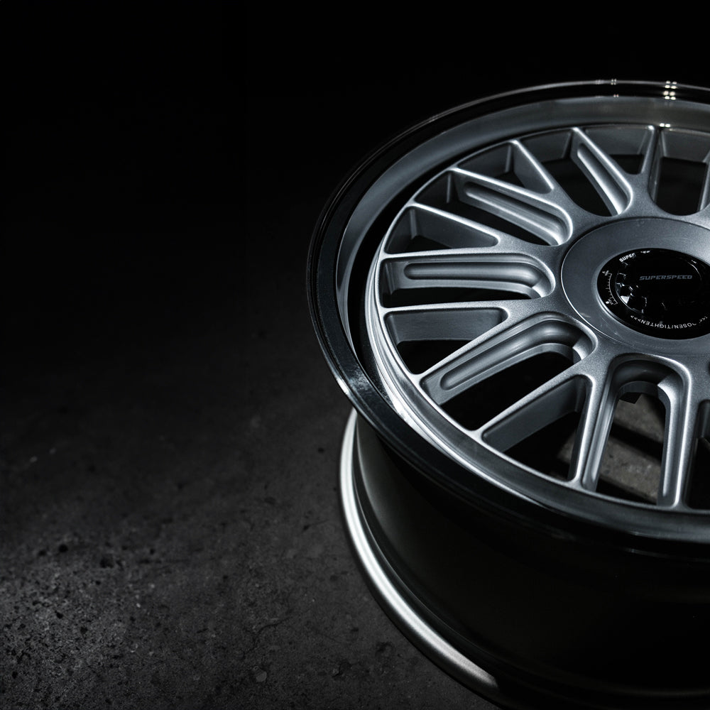 Close-up of a silver alloy wheel on a dark background